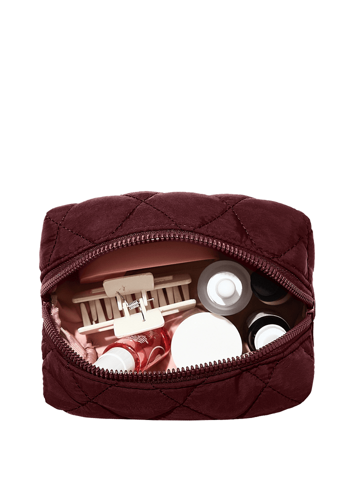 Quilted brown makeup bag with cosmetic items on a transparent background