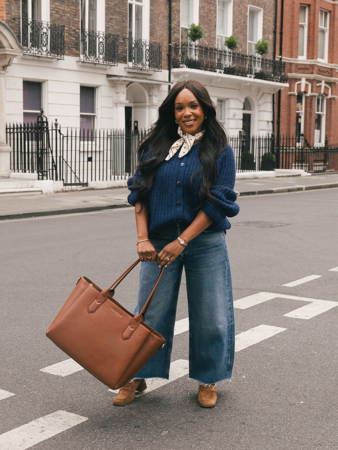 Poppy & Peonies Double Duty Tote in Chestnut carried by the top handles while standing on a city street.