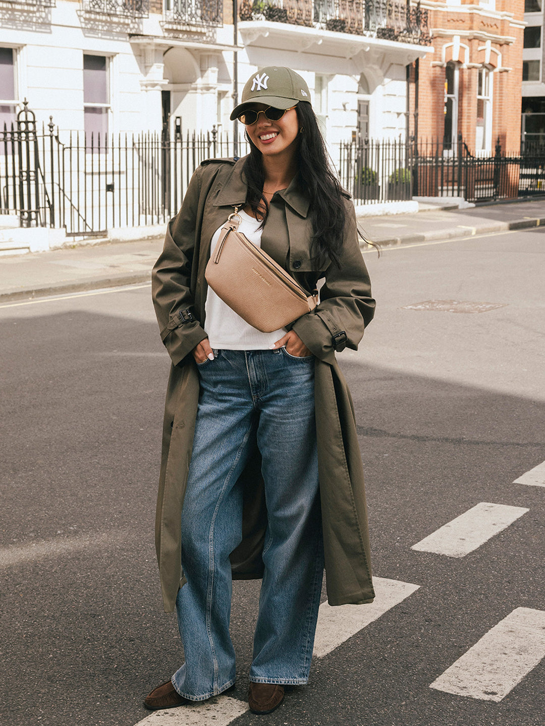 Woman standing with the Poppy & Peonies The Sidekick in Taupe worn across her chest on a city street.
