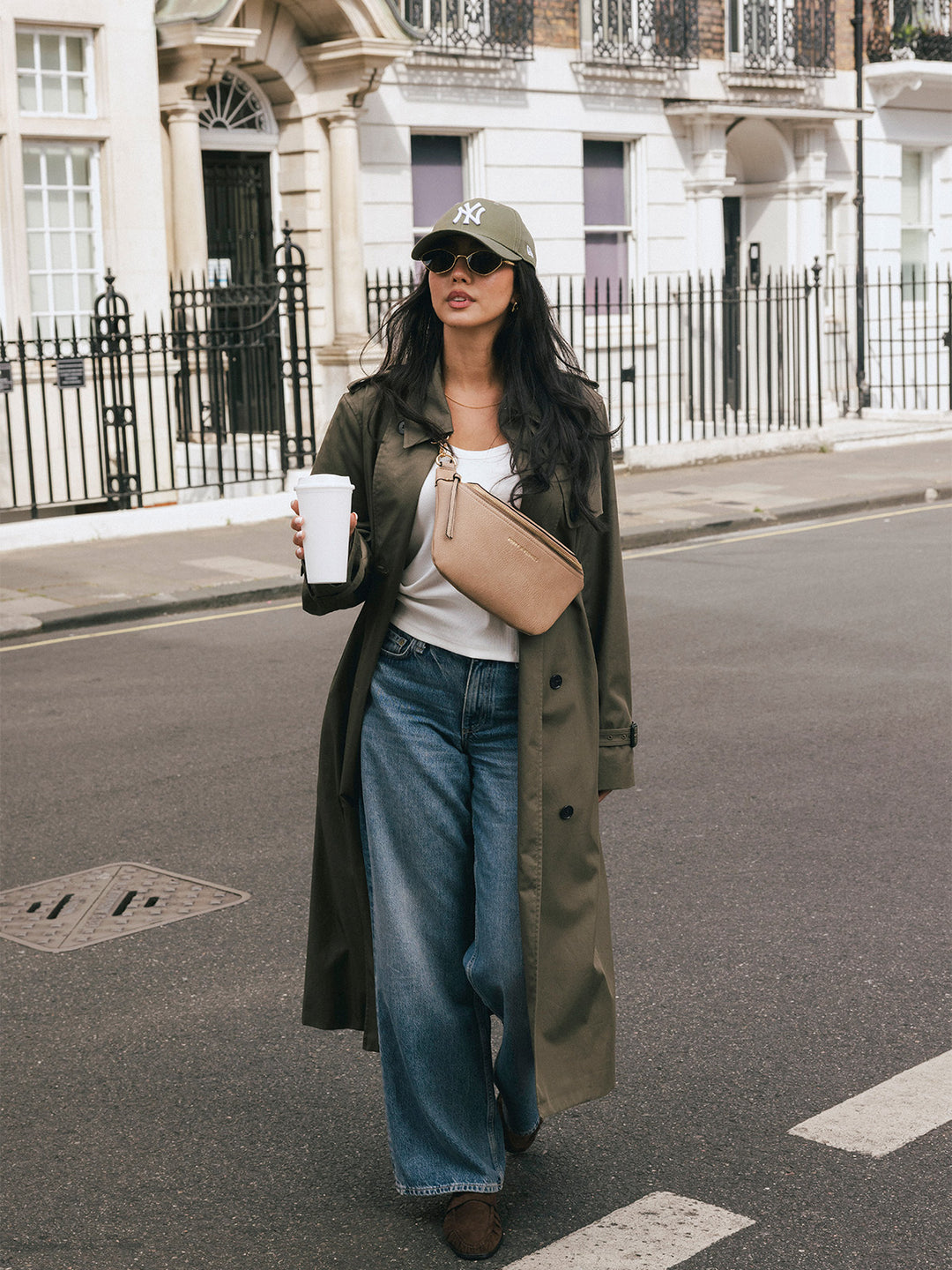 Woman walking with the Poppy & Peonies The Sidekick in Taupe worn across her chest while holding a takeaway cup.