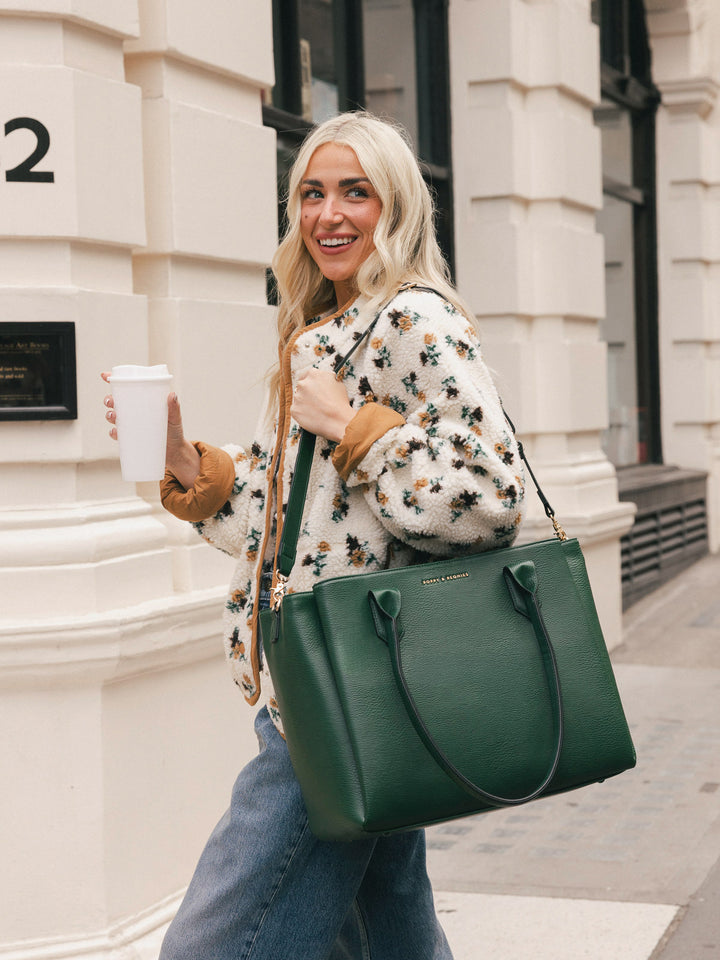 Woman carrying the Poppy & Peonies Double Duty Tote in Heritage Green over the shoulder with the top handles.