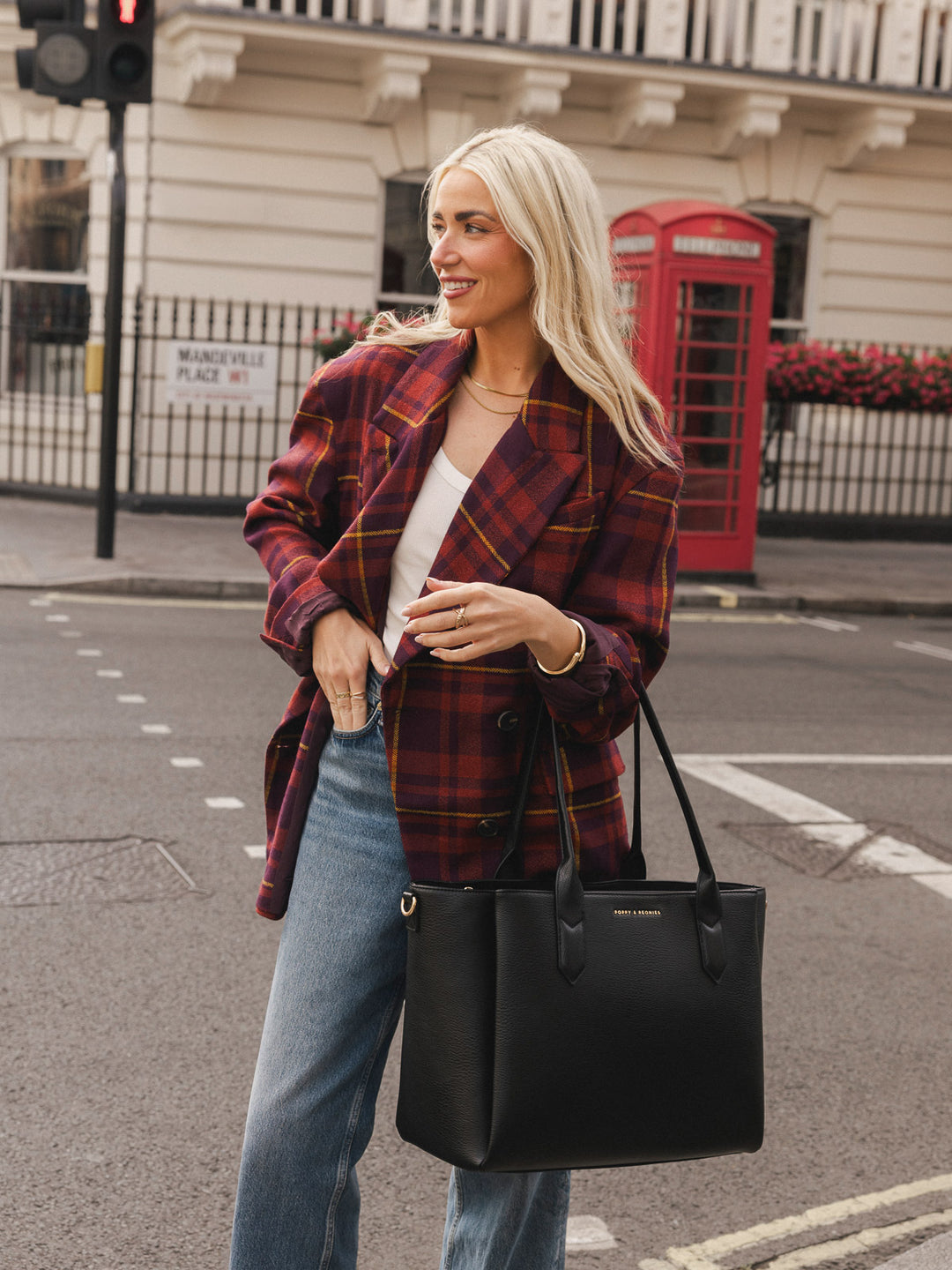 Woman carrying the Poppy & Peonies Double Duty Tote in Black with top handles.