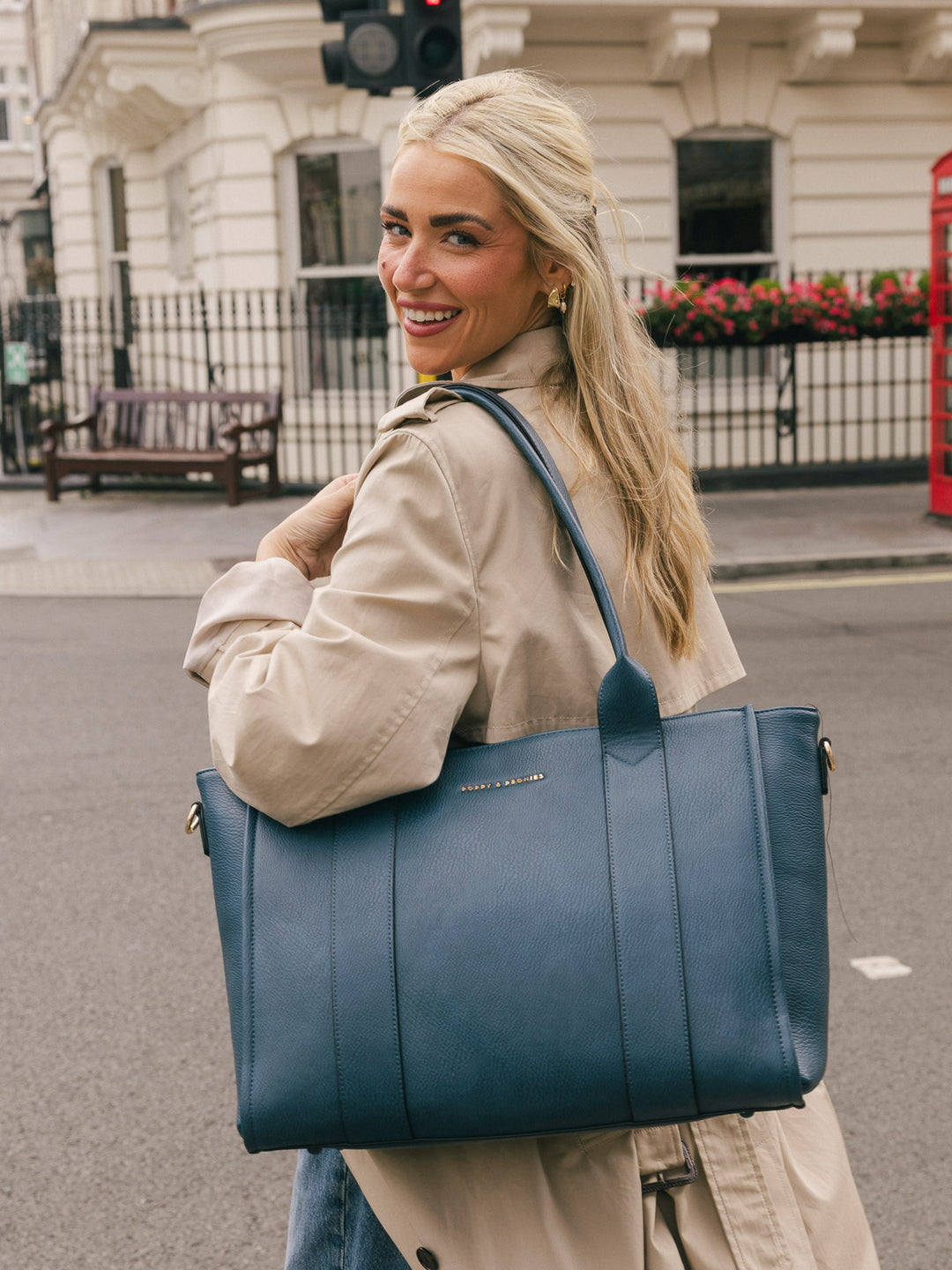 Closer lifestyle shot of a woman carrying the Poppy & Peonies Multitasker in Navy over her shoulder.