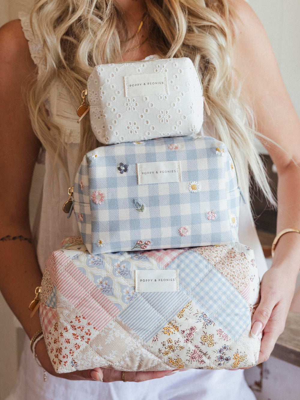 Stack of patterned cosmetic bags held by a person