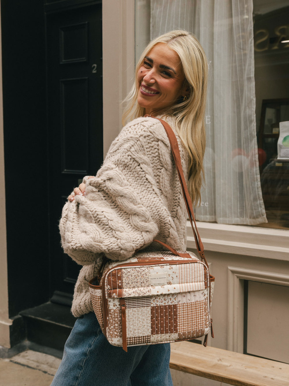 Lifestyle shot of a woman wearing the Poppy & Peonies Basic Lunch Bag in Brown Patchwork over her shoulder.