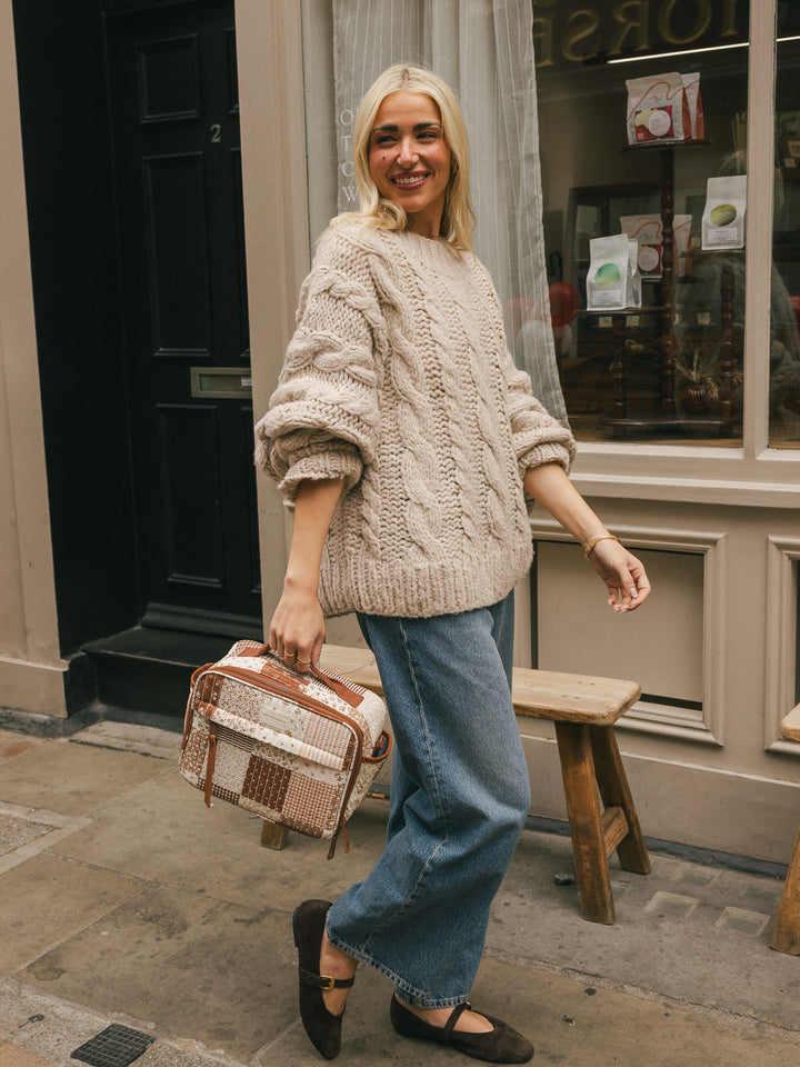 Full-body lifestyle shot of a woman carrying the Poppy & Peonies Basic Lunch Bag in Brown Patchwork by its top handle.