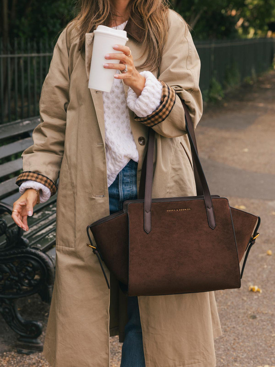 Poppy & Peonies Mini Avenue Tote in Espresso Suede carried by hand during a riverside walk, highlighting its compact everyday silhouette.