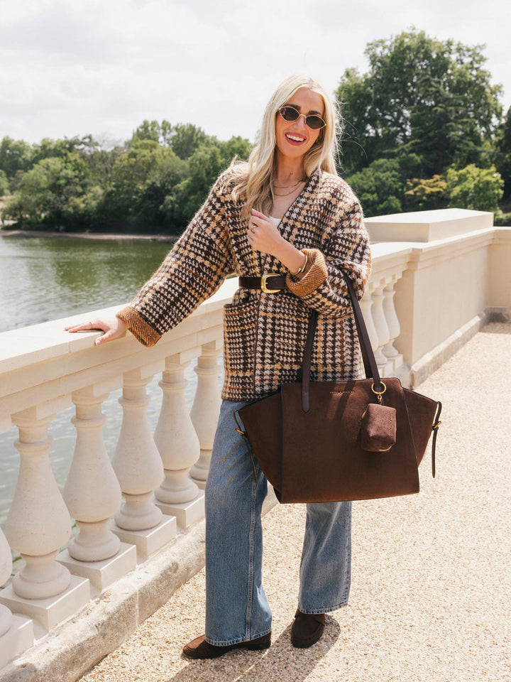 Poppy & Peonies Avenue Tote in Espresso Suede carried by the top handles while walking outdoors, highlighting its spacious everyday design and soft suede finish.