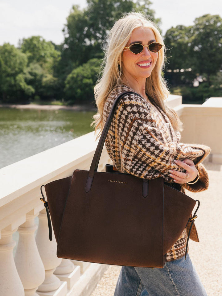 Poppy & Peonies Avenue Tote in Espresso Suede worn over the shoulder during a sunny outdoor outing, showcasing its spacious silhouette and long shoulder straps.