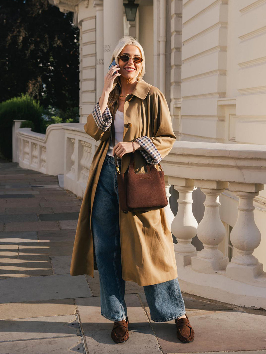 Poppy & Peonies The Pick Me Up Tote in Espresso Suede styled outdoors, showing its compact silhouette and rich brown suede exterior.