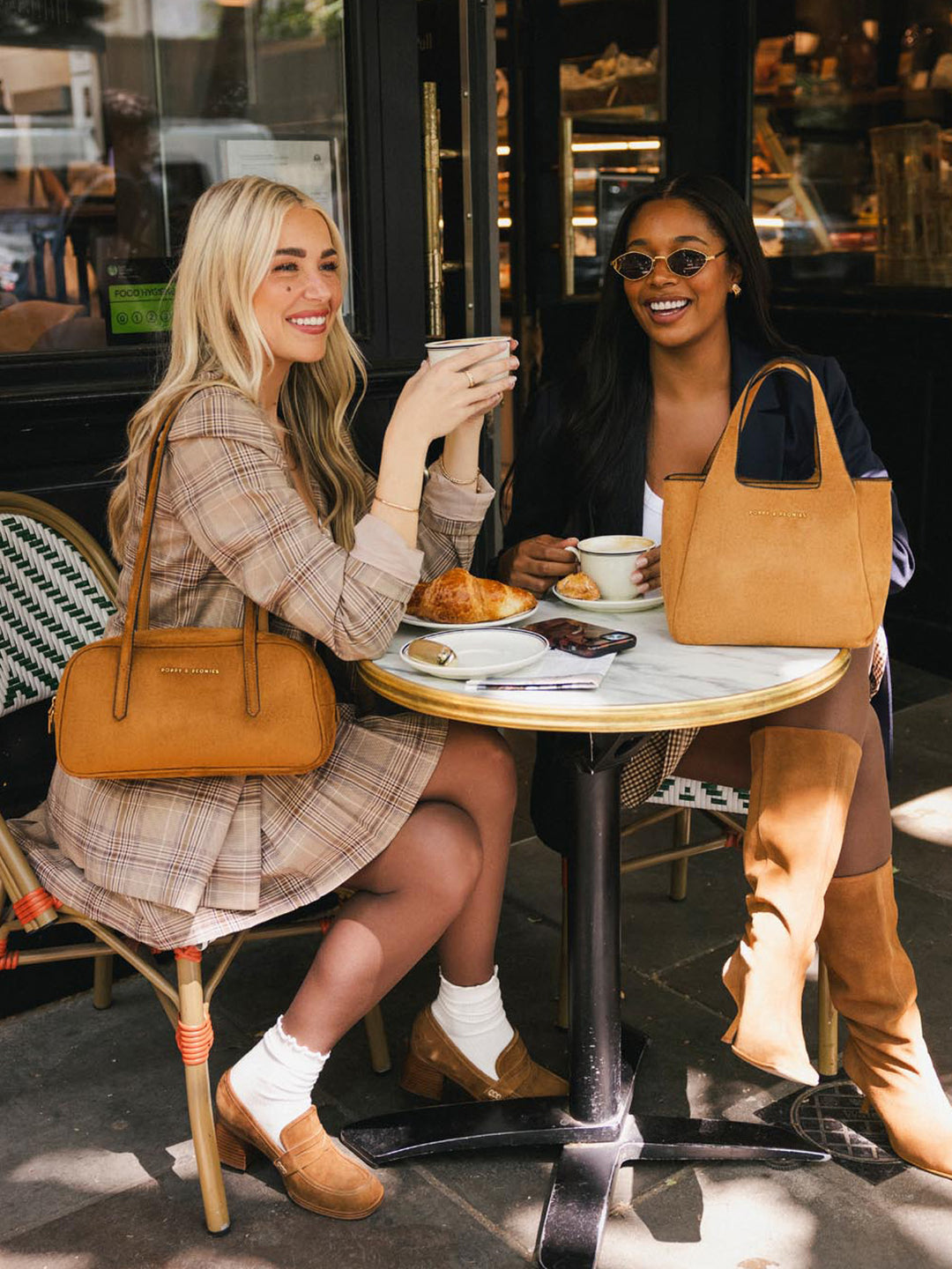 Poppy & Peonies The Pick Me Up Tote in Cognac Suede displayed beside The Friday Satchel during an outdoor café outing.
