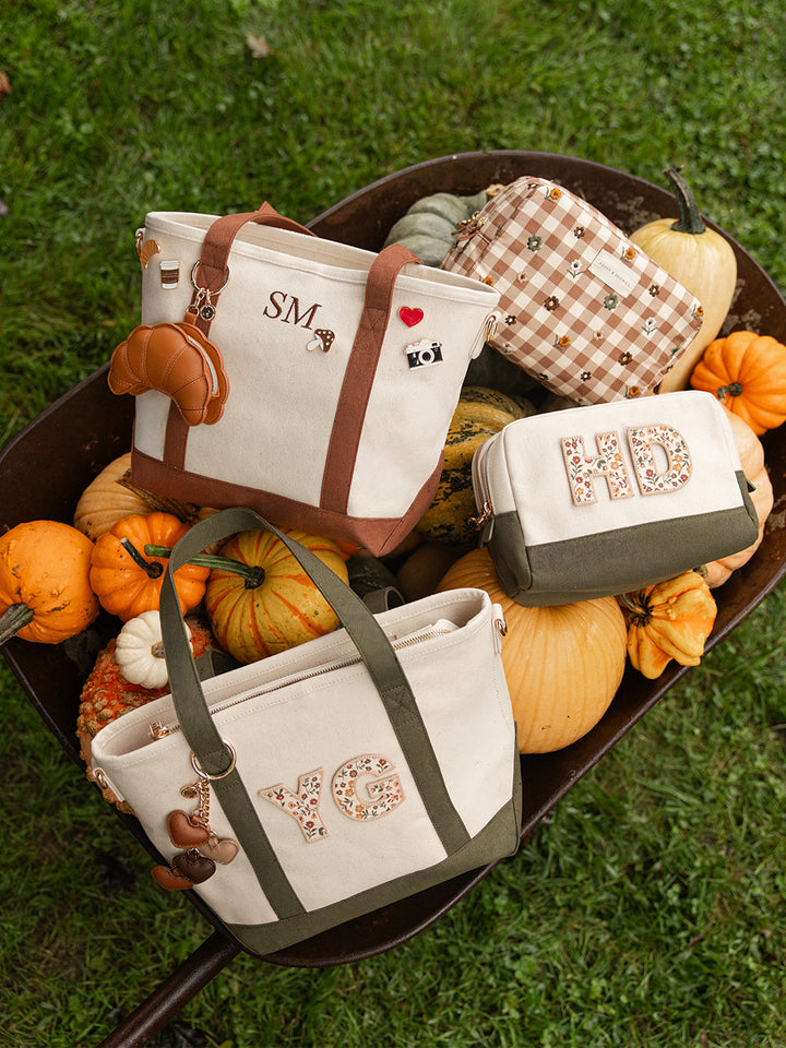 Poppy & Peonies Country Cozy Collection featuring personalized canvas totes and cosmetic cases in Chestnut and Olive, arranged among pumpkins and autumn gourds.