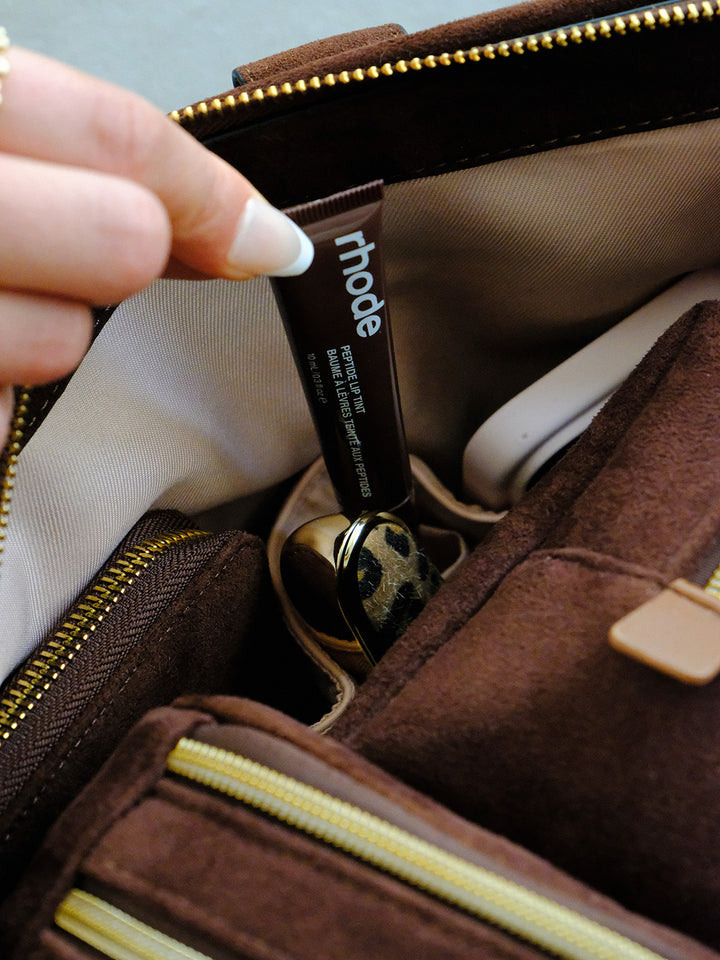 Poppy & Peonies Bag Interior in Espresso Suede interior close-up, highlighting blush organizational pockets holding beauty essentials and small accessories.
