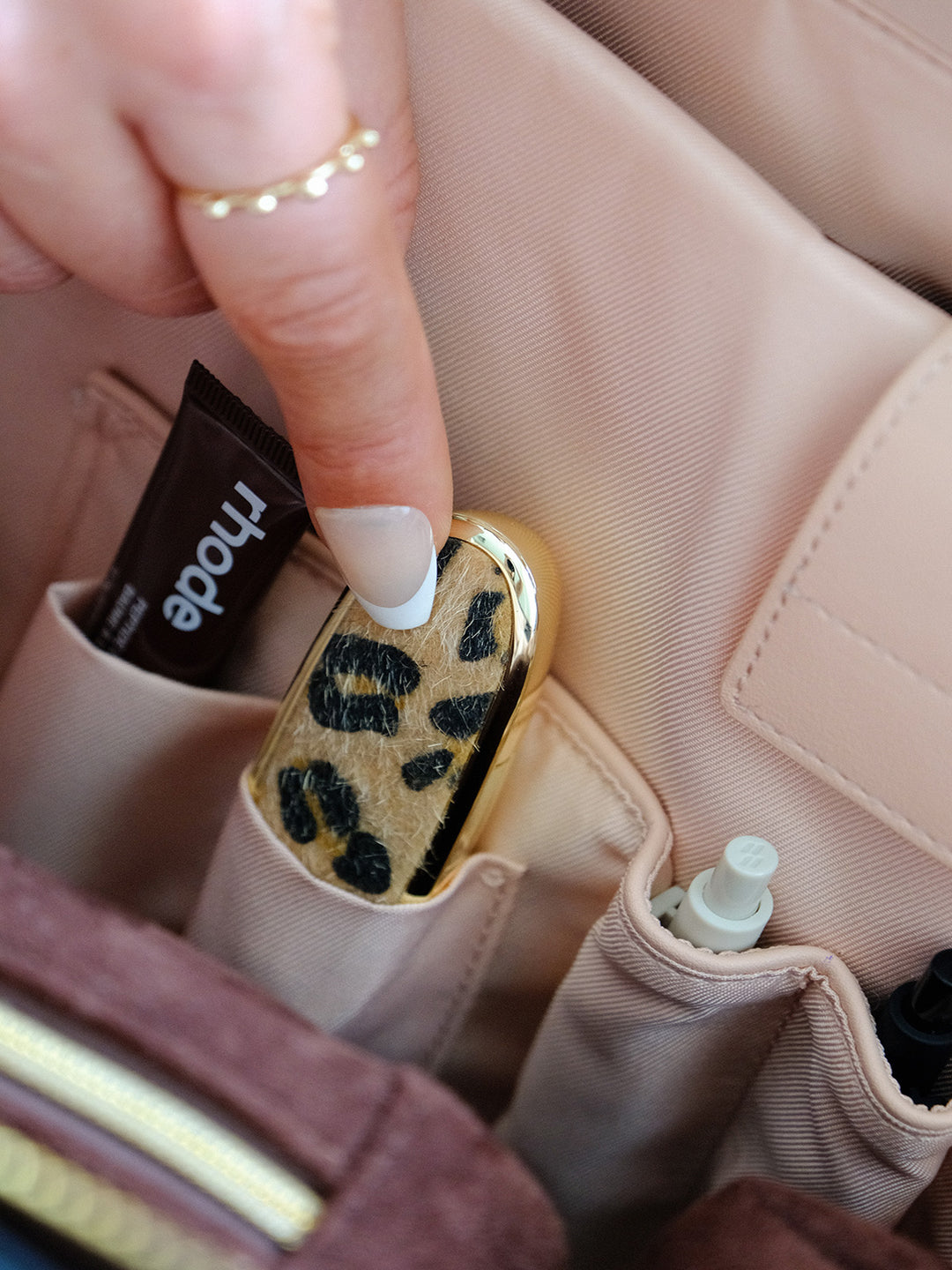 Poppy & Peonies Avenue Tote in Espresso Suede interior close-up, highlighting blush organizational pockets holding beauty essentials and small accessories.