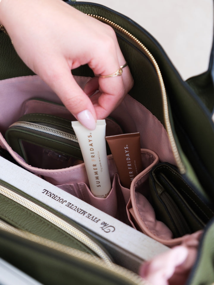Close-up of the Uptown Tote in Olive highlighting its interior organization with dedicated pockets for beauty products, a wallet, and everyday essentials.
