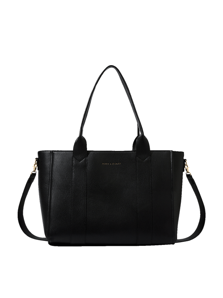 Poppy and Peonies Multitasker Black tote bag featuring a textured black exterior, dual shoulder handles, detachable crossbody strap, gold-tone hardware, and subtle front logo detailing.