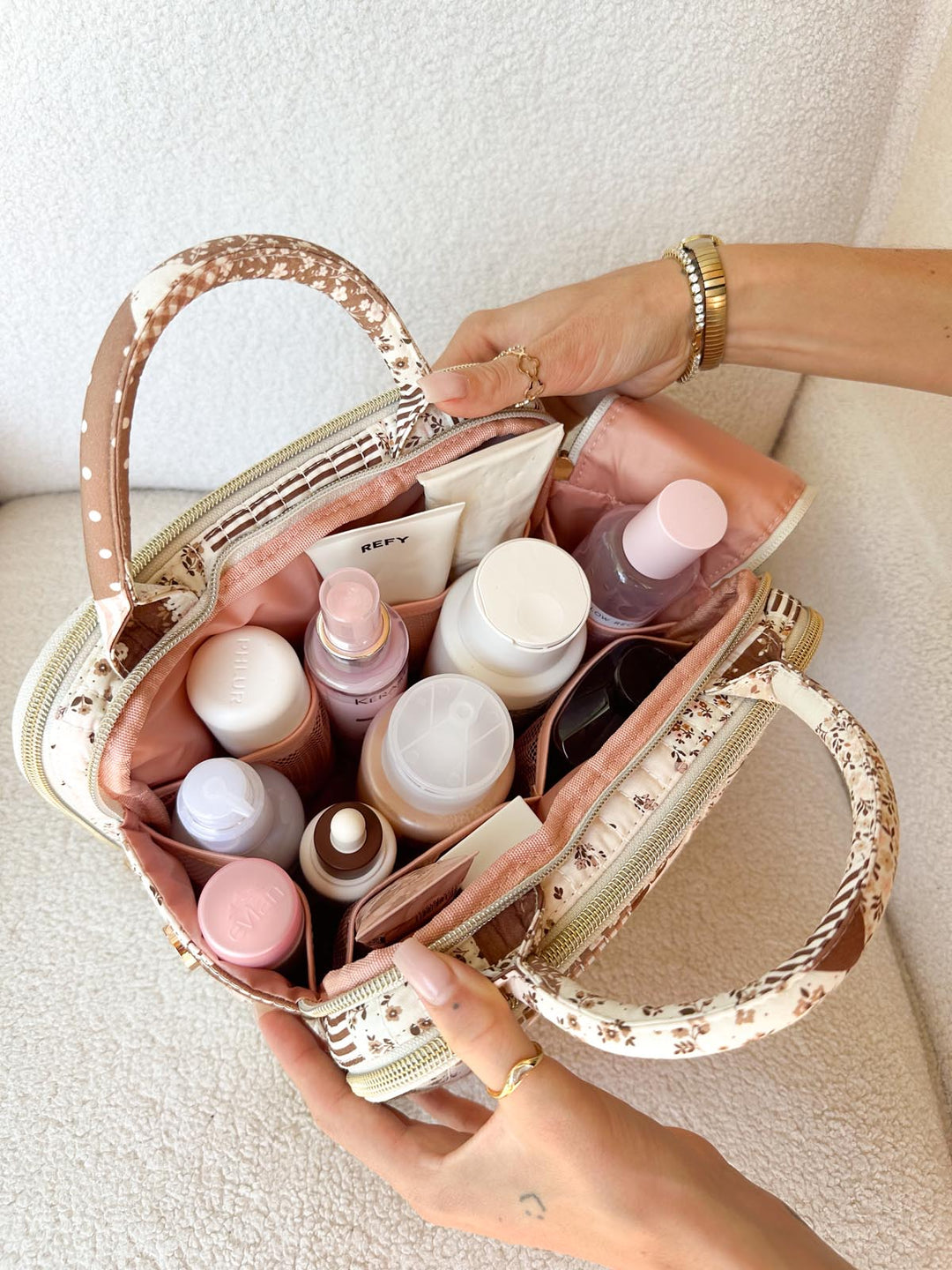 Poppy & Peonies The Routine Cosmetic Case in Brown Patchwork filled with skincare and beauty essentials.