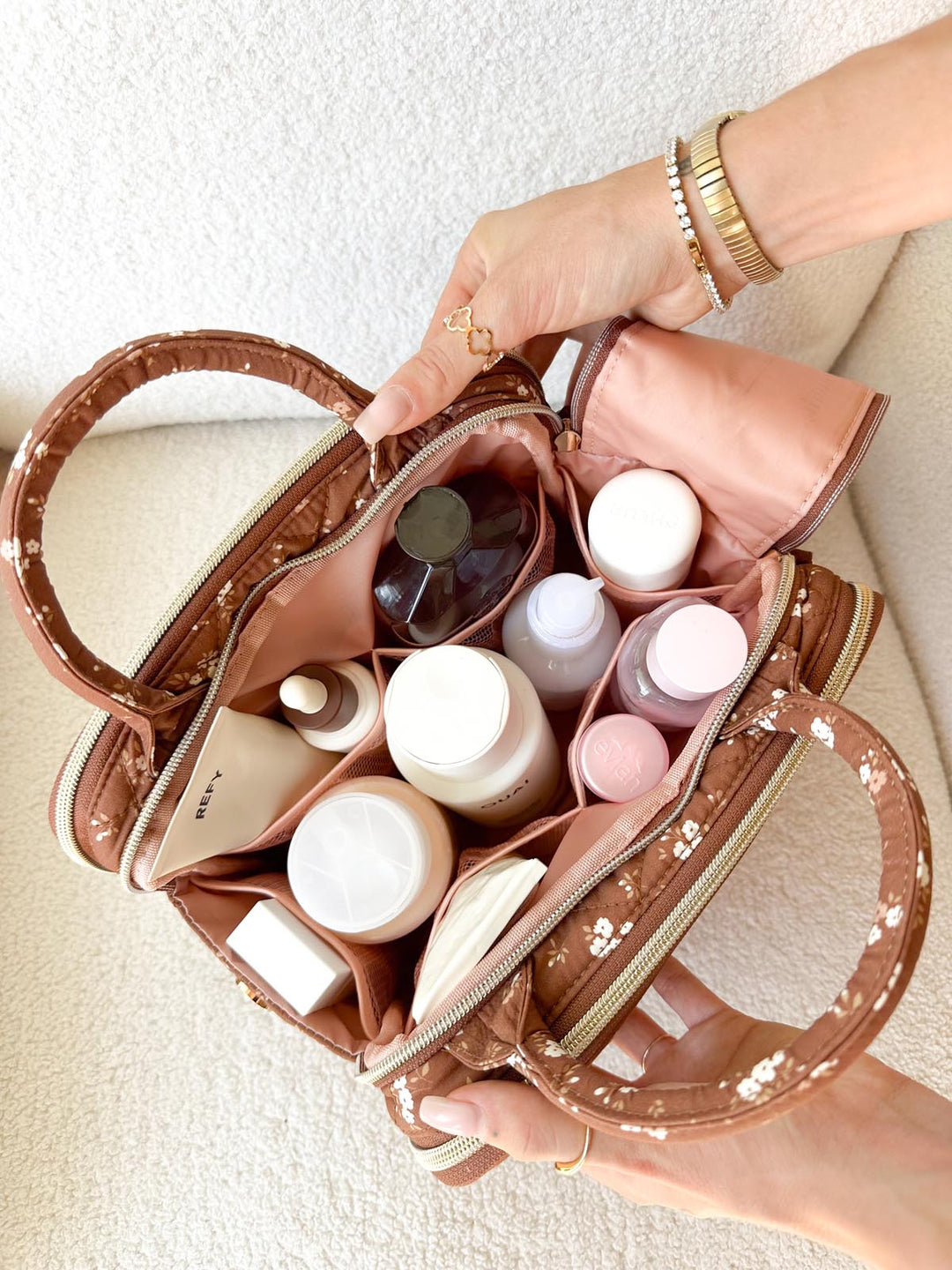 Poppy & Peonies The Routine Cosmetic Case in Brown Floral filled with skincare and beauty essentials.