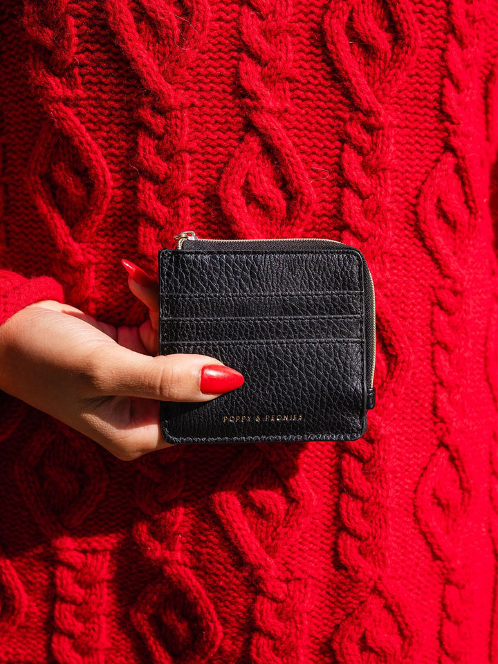 Person holding a vegan leather black wallet