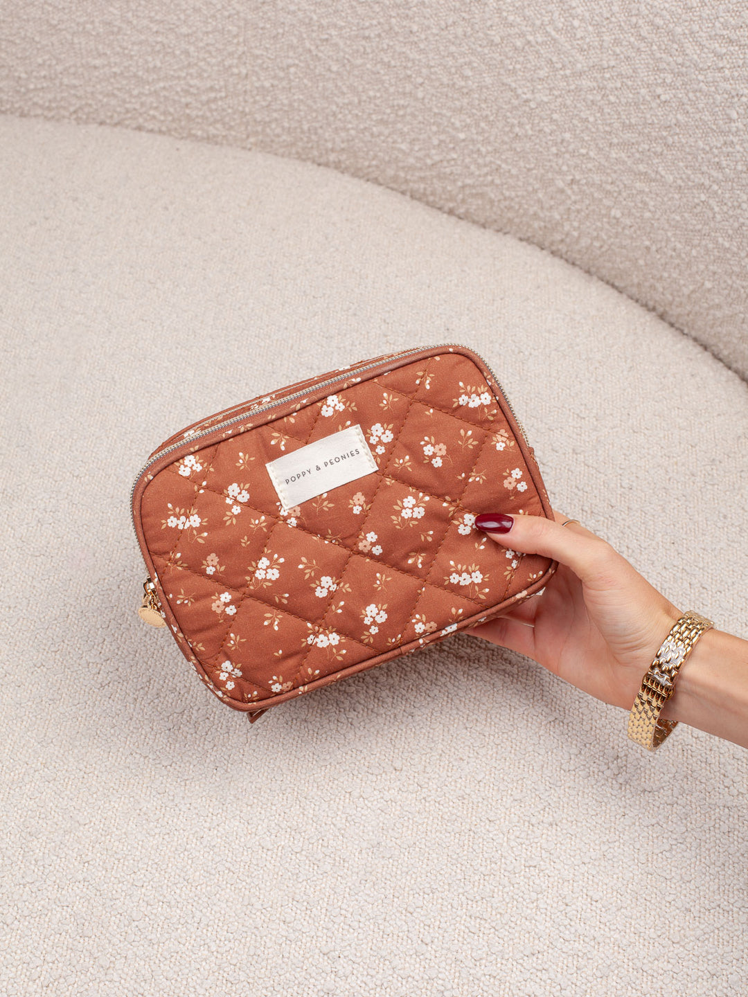 Handheld lifestyle shot of the Poppy & Peonies Split Organizer in Brown Floral, highlighting its compact size, quilted texture, and floral print.