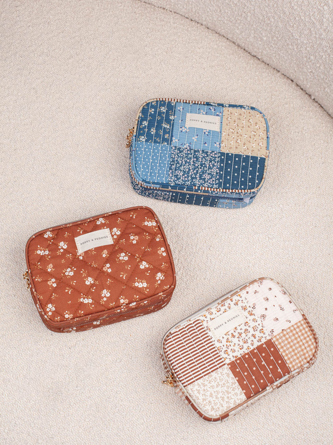 Product shot featuring the Poppy & Peonies The Split Organizer in Brown Floral, Brown Patchwork, and Navy Patchwork together, showcasing all three patterned colorways in one coordinated collection image.