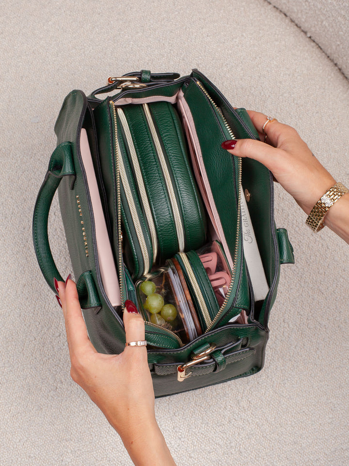 Top-down lifestyle shot of the Mini Uptown Tote in Heritage Green, showcasing its structured interior with multiple organizers and essentials stored neatly inside.