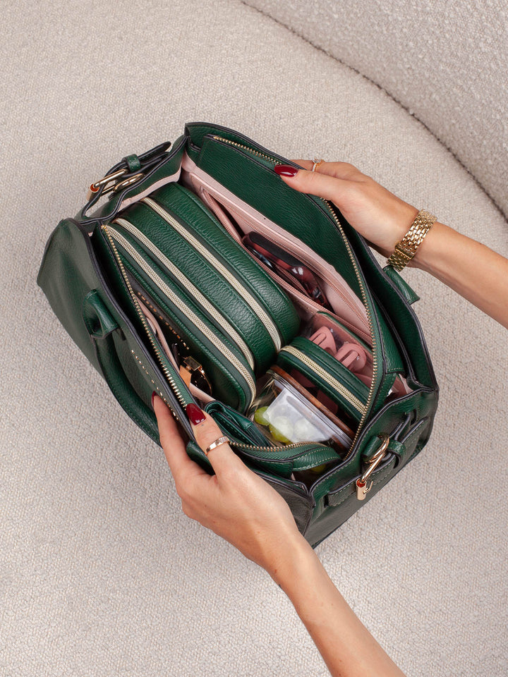 Overhead lifestyle shot of the Mini Uptown Tote in Heritage Green, showcasing its spacious interior with coordinating organizers and everyday essentials neatly arranged inside.
