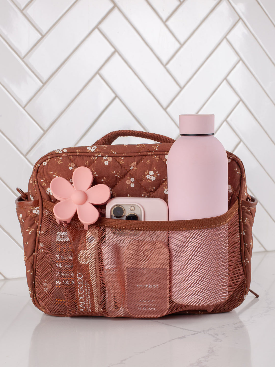 Poppy & Peonies The Lunch Box in Brown Floral with water bottle and essentials in exterior pockets.