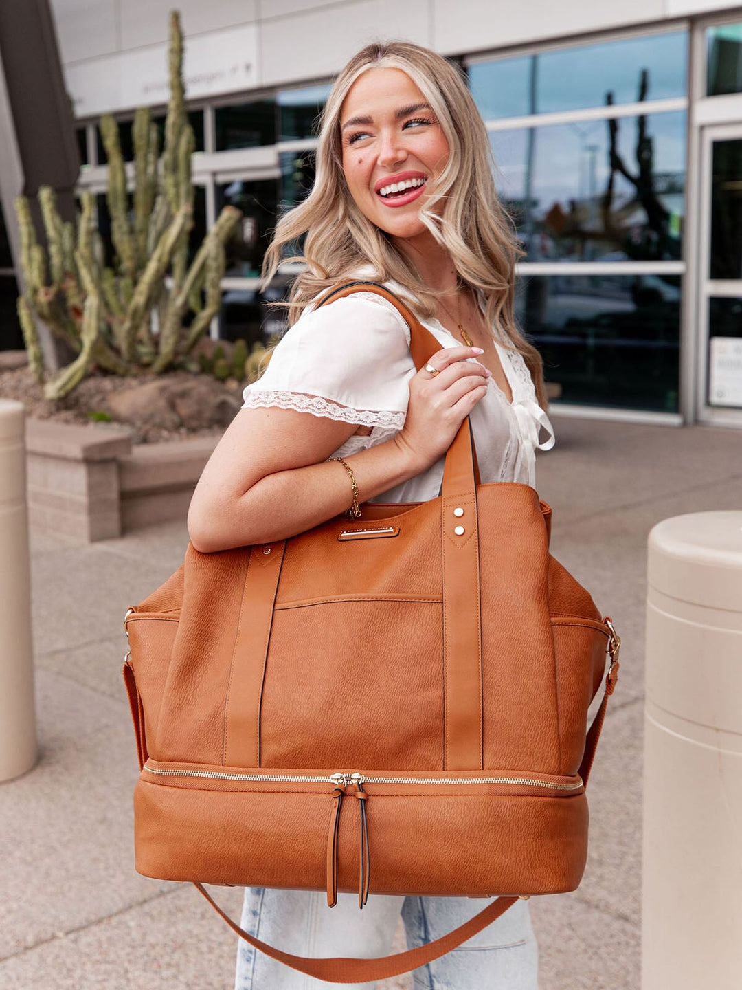 Woman holding a brown vegan leather travel bag outdoors