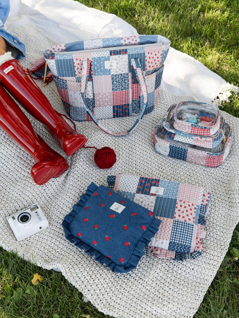 Poppy & Peonies Analog Tote in Strawberry Patchwork styled outdoors with coordinating Strawberry Patchwork and Strawberry Denim accessories, knitting essentials, camera and red rain boots.