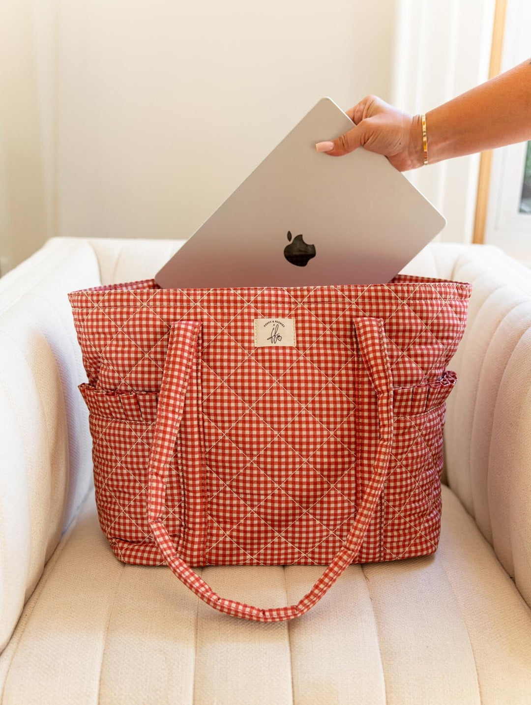 Poppy & Peonies Analog Tote in Heart Berry Gingham lifestyle view, showing a laptop being placed into the tote’s padded laptop compartment.