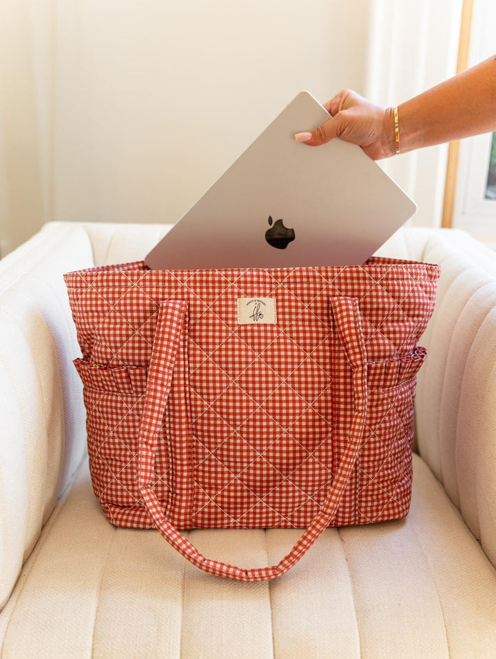 Poppy & Peonies Analog Tote in Heart Berry Gingham lifestyle view, showing a laptop being placed into the tote’s padded laptop compartment.