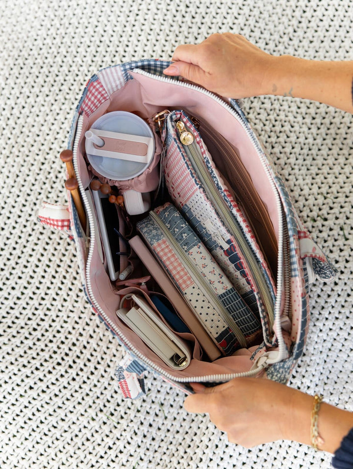 Poppy & Peonies Analog Tote in Strawberry Patchwork open top view, packed with a travel mug, notebooks, knitting needles and coordinating organizers inside the blush-pink interior.