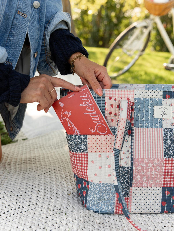 Poppy & Peonies Analog Tote in Strawberry Patchwork exterior pocket close-up, showing a book being placed into the large front slip pocket.