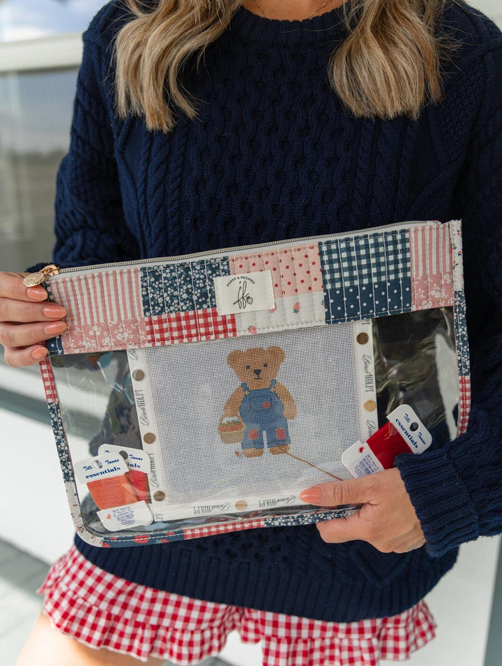 Poppy & Peonies She’s a WIP Bag in Strawberry Patchwork lifestyle view, held with a needlepoint project and embroidery thread visible through the clear front panel.