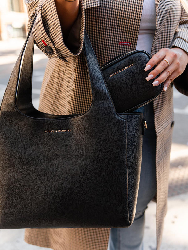 Poppy & Peonies Pretty Connected Case in Black lifestyle close-up, styled alongside The Companion Tote and featuring its structured zip-around design.