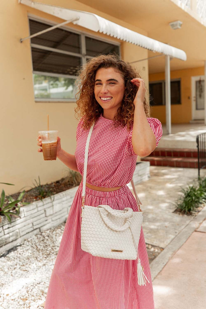 Woman holding a cream coloured woven tote bag