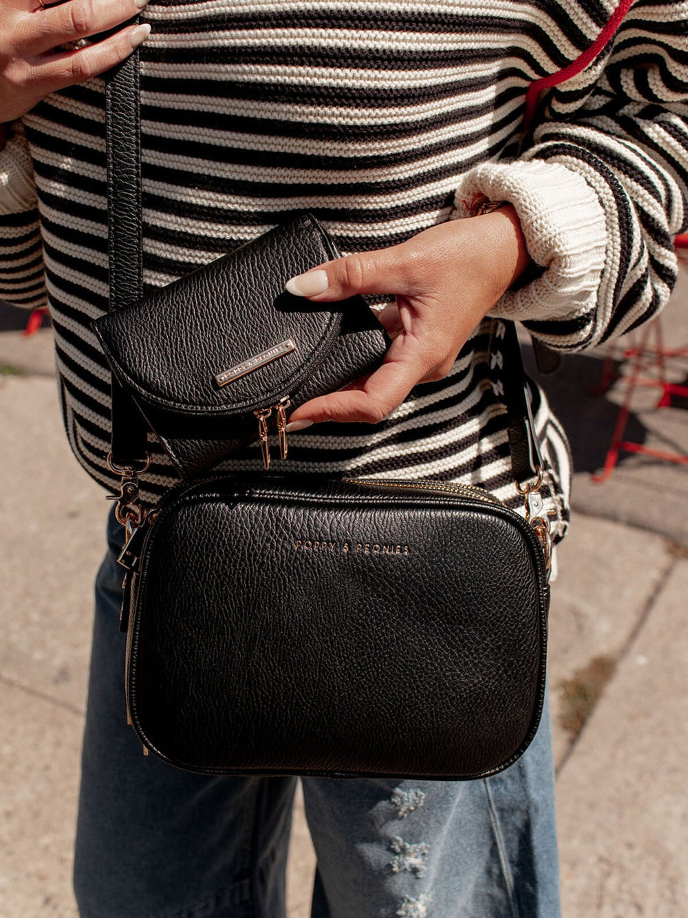 Woman holding a vegan leather crossbody bag with matching wallet