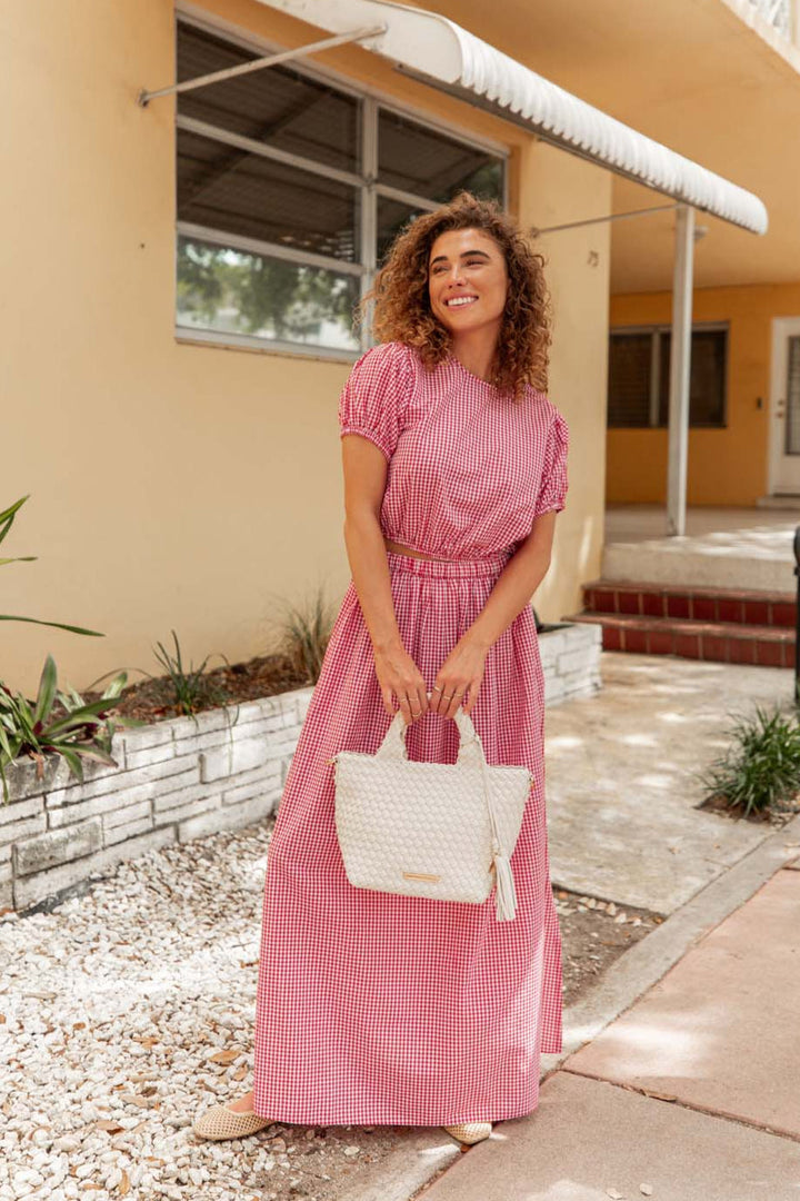 Woman holding a cream coloured woven tote bag