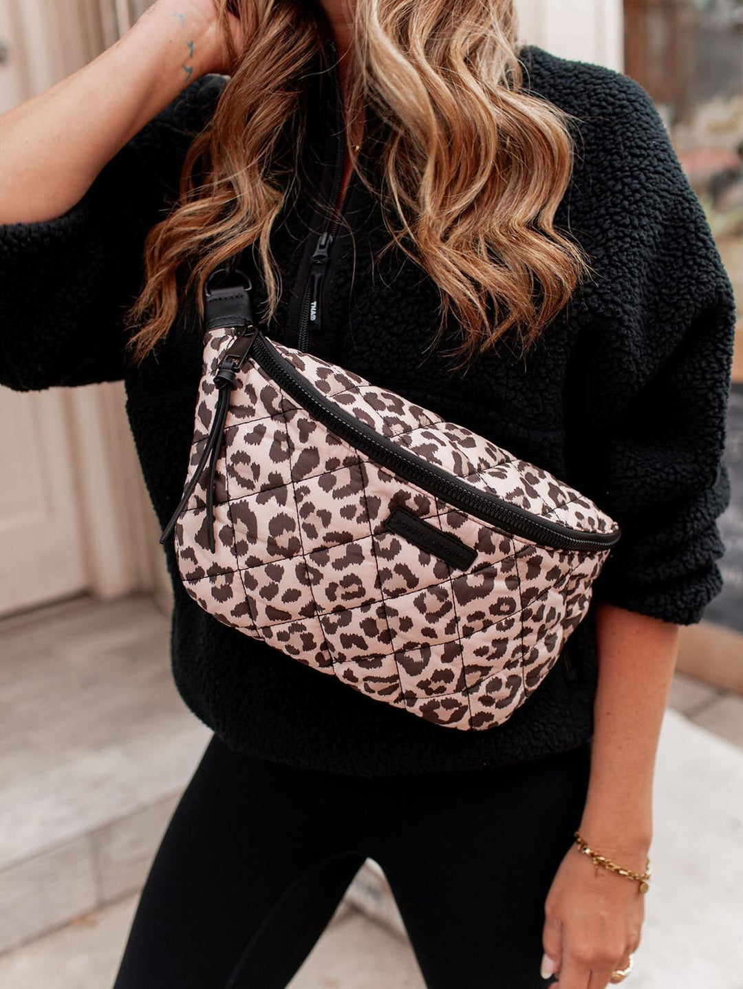 Person wearing a leopard print crossbody bag with a blurred background