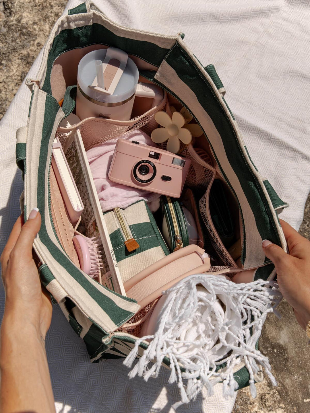 Open tote bag with travel items including a camera, toiletries, and clothing.