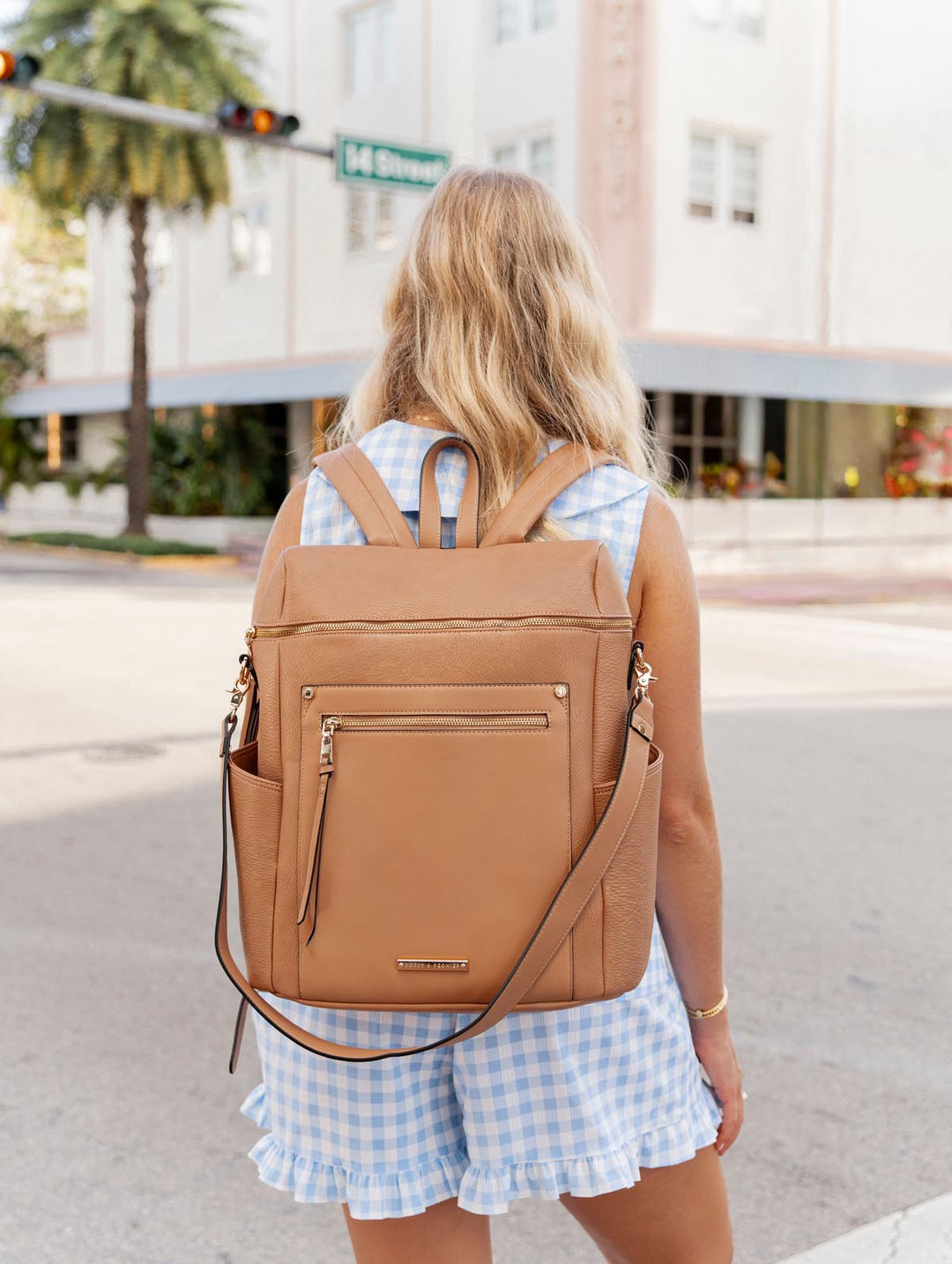 Person wearing light brown vegan leather backpack