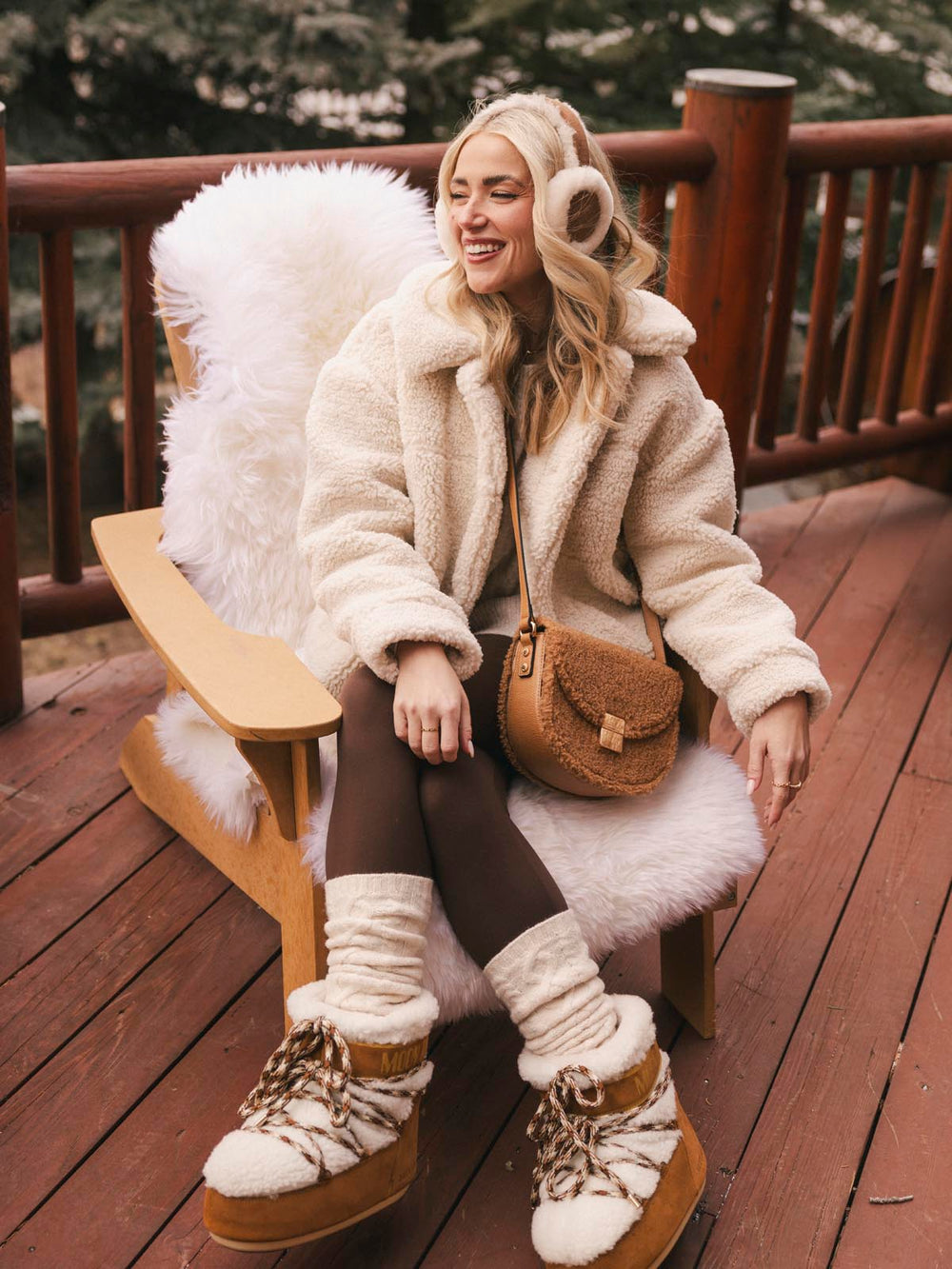 Woman in a fluffy white coat wearing a brown faux fur crossbody bag with a vegan leather strap