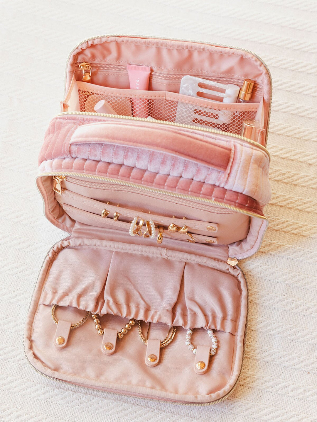 Interior of a pink velvet quilted cosmetic bag with a handle