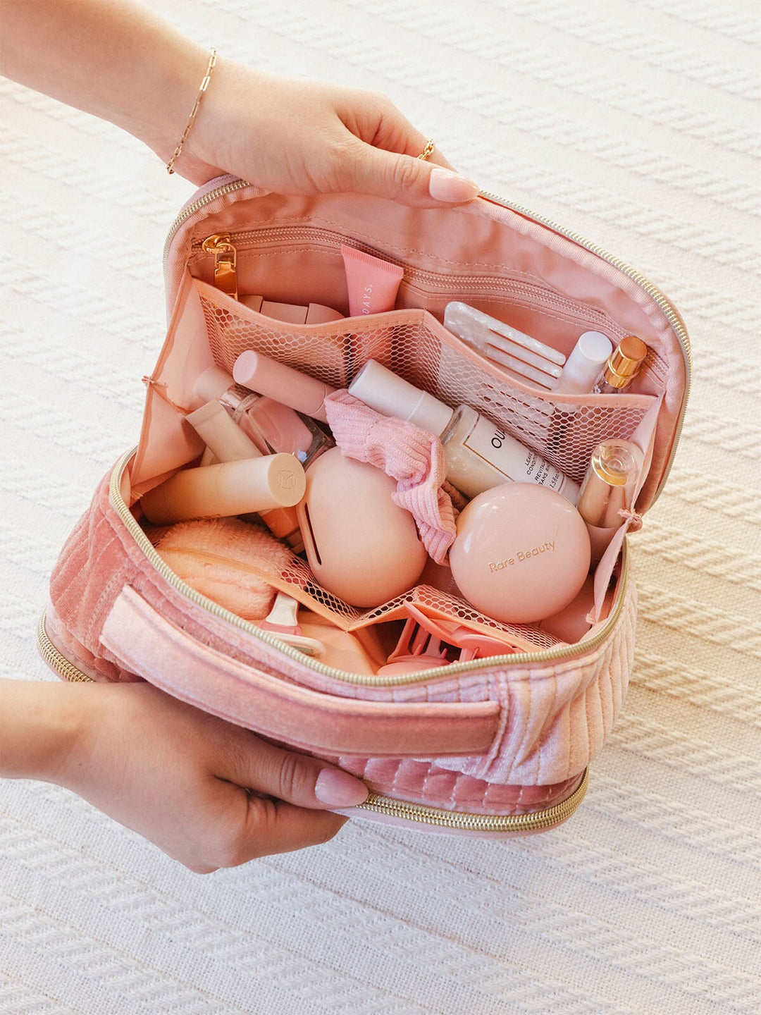 Interior of a pink velvet quilted cosmetic bag with a handle