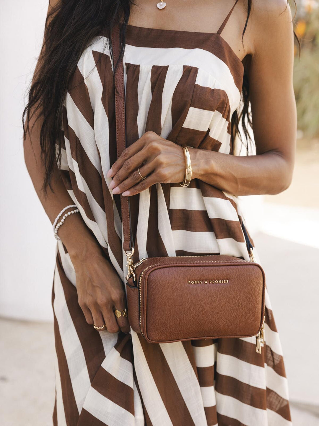 Woman holding a brown vegan leather crossbody