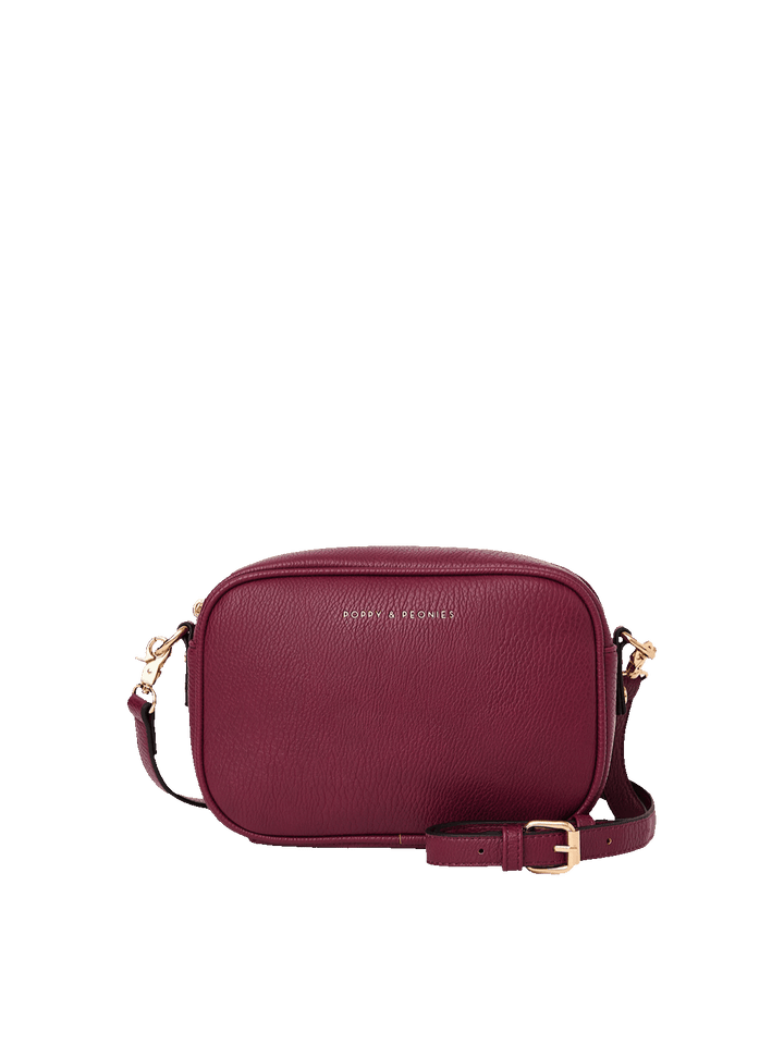 Poppy and Peonies 24/7 Crossbody Berry featuring a compact rectangular silhouette, textured berry-colored exterior, gold-tone logo, dual zippered compartments, and adjustable shoulder strap