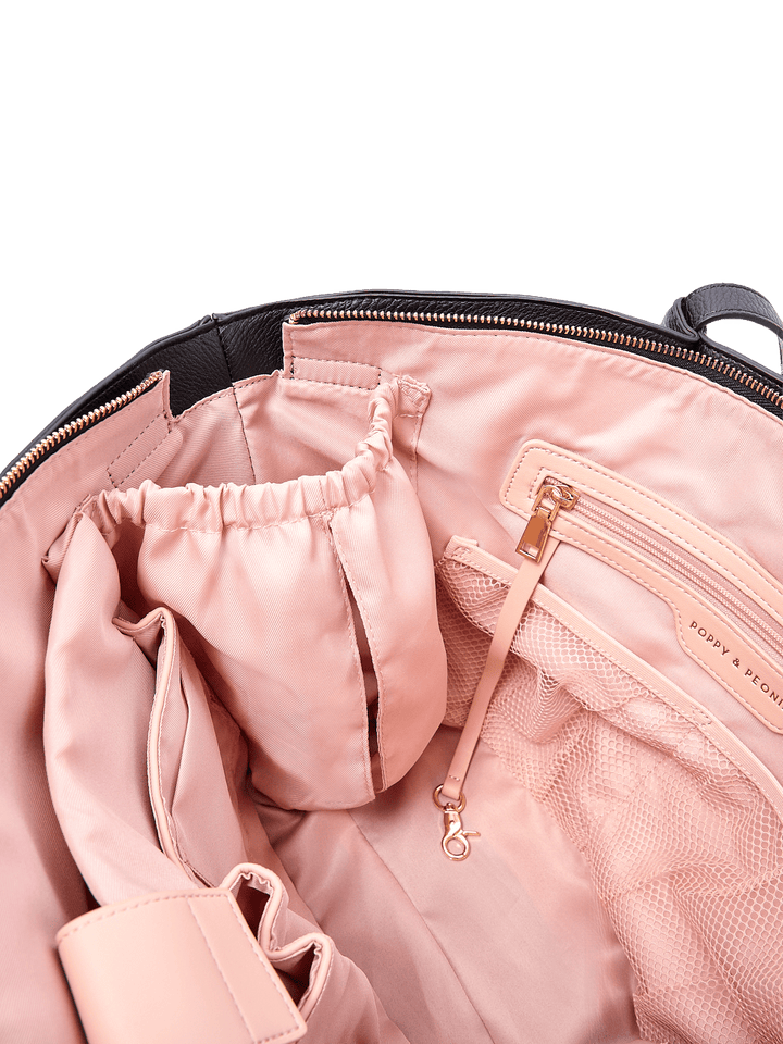 Poppy & Peonies The Knot Tote in Black, showing blush pink lining, a zippered pocket with gold-tone hardware, mesh organizer pockets, and interior storage compartments.
