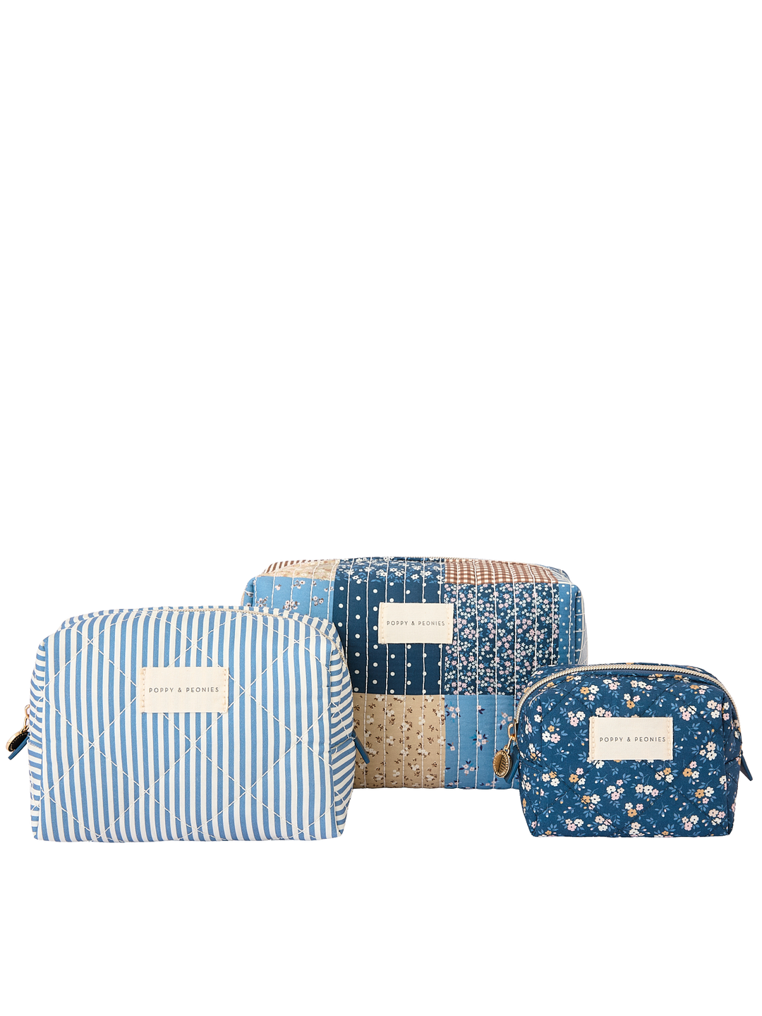 Clean product shot of the Poppy & Peonies Cosmetic Trio in Navy Patchwork, featuring all three coordinating cosmetic cases together: a blue-and-white striped case, a navy patchwork case, and a navy floral case.