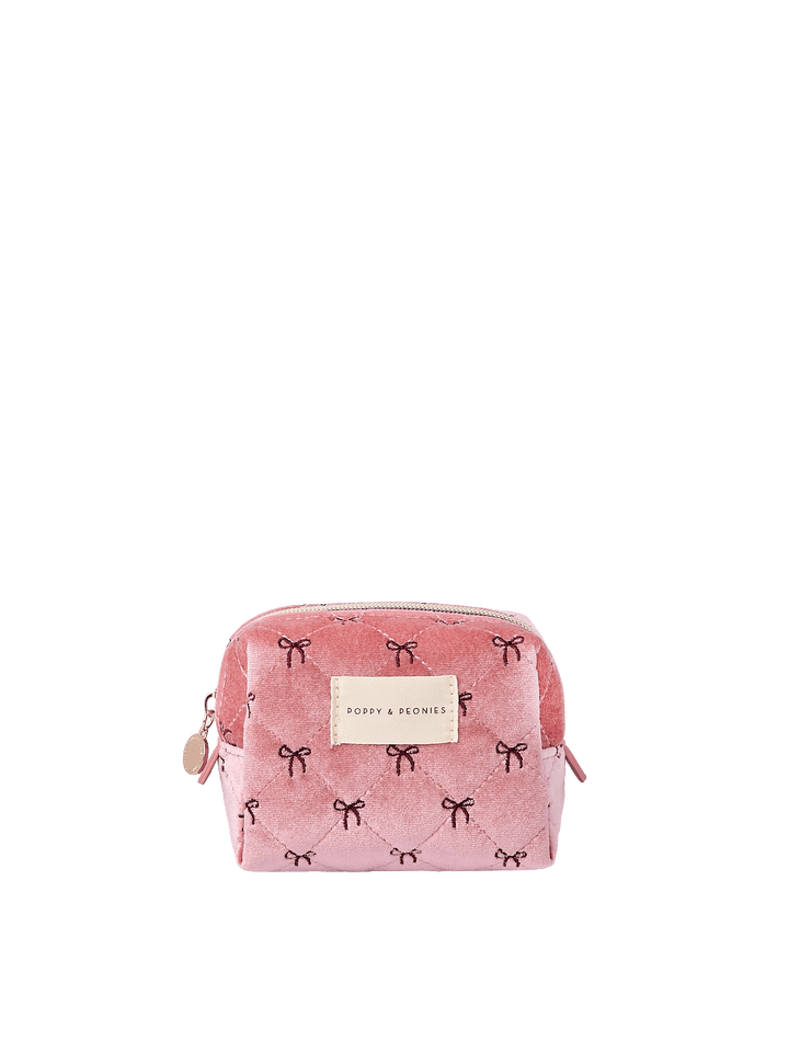Poppy and Peonies Cosmetic Trio Floral featuring the small pink cosmetic pouch with delicate black bow patterns, compact rectangular silhouette, gold-tone zipper closure, and rectangular Poppy and Peonies logo plate on the front.
